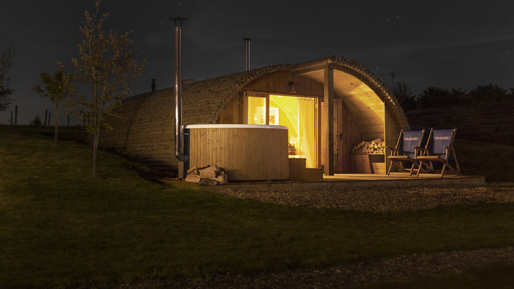 A night picture of the Skargards Regal standing next to a wooden house.