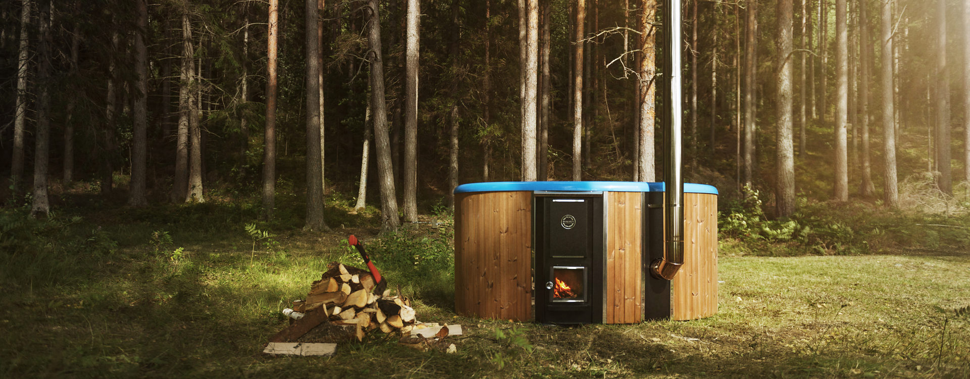Skargards Regal wood-burning hot tub placed next to a pile of wood in the Swedish nature.